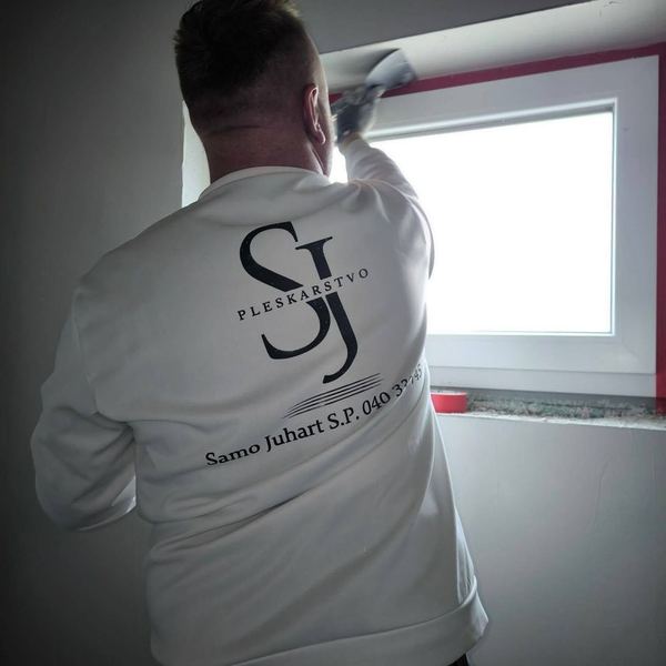 Samo Juhart pri delu: glajenje stene ob oknu